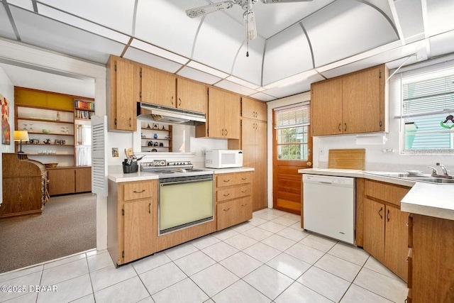 918 N Wild Olive Ave, Daytona Beach, FL 32118 - kitchen with white appliances, under cabinet range hood, light countertops, and light tile patterned flooring