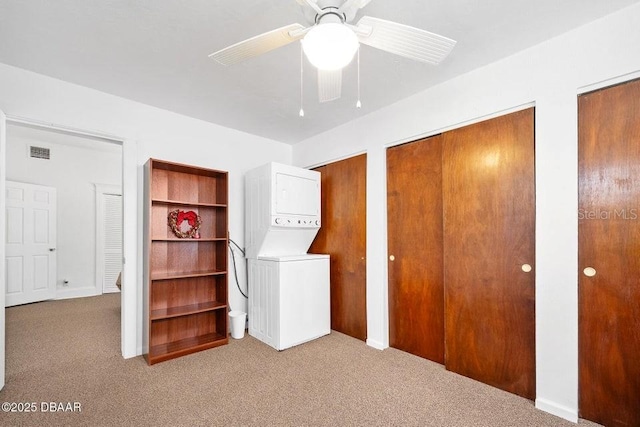 918 N Wild Olive Ave, Daytona Beach, FL 32118 - unfurnished bedroom featuring estacked washer and dryer, multiple closets, carpet, and a ceiling fan