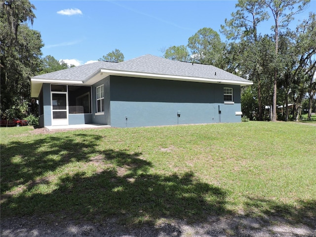 400 S County Road 115, Bunnell, FL 32110 - view of side of home with a sunroom, stucco siding, a lawn, and a shingled roof