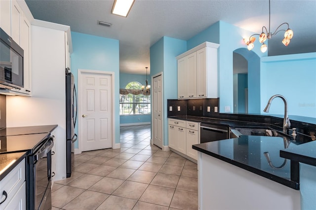 38 Mount Vernon Ln, Palm Coast, FL 32164 - kitchen with black appliances, a chandelier, light tile patterned flooring, and white cabinets