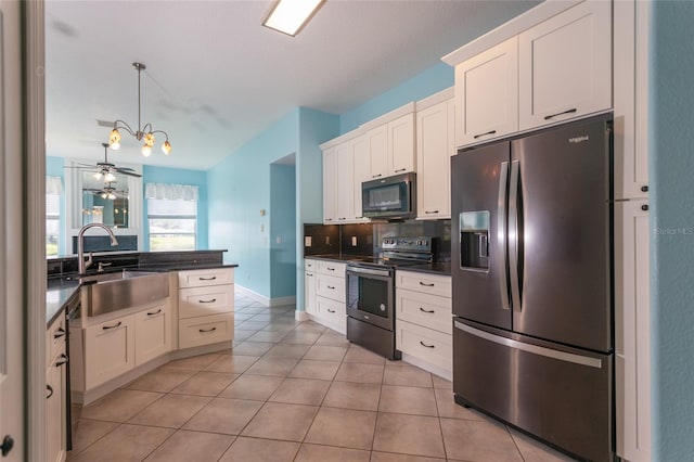38 Mount Vernon Ln, Palm Coast, FL 32164 - kitchen featuring appliances with stainless steel finishes, dark countertops, light tile patterned floors, white cabinets, and hanging light fixtures