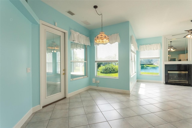 38 Mount Vernon Ln, Palm Coast, FL 32164 - unfurnished dining area with a chandelier, tile patterned flooring, a glass covered fireplace, and a ceiling fan