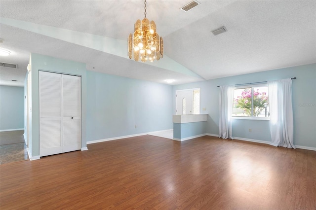 1 Wilson Pl, Palm Coast, FL 32164 - unfurnished living room with a chandelier, wood finished floors, lofted ceiling, and a textured ceiling