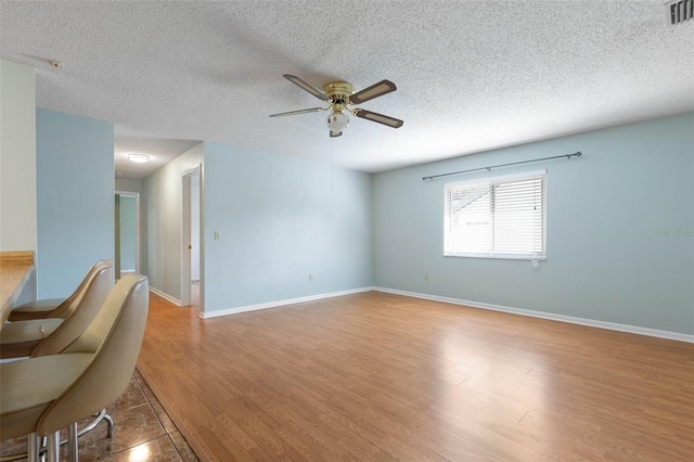 1 Wilson Pl, Palm Coast, FL 32164 - unfurnished living room featuring a ceiling fan, a textured ceiling, and wood finished floors