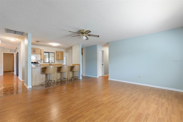 1 Wilson Pl, Palm Coast, FL 32164 - unfurnished living room with light wood-style flooring, ceiling fan, and a textured ceiling