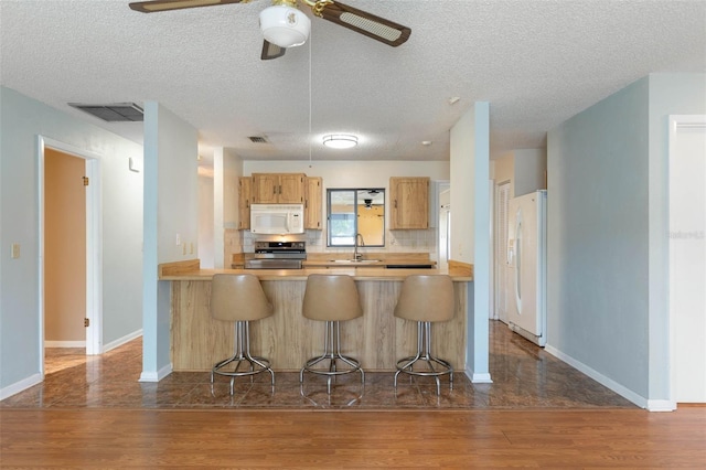 1 Wilson Pl, Palm Coast, FL 32164 - kitchen featuring white appliances, dark wood-type flooring, ceiling fan, light countertops, and a textured ceiling