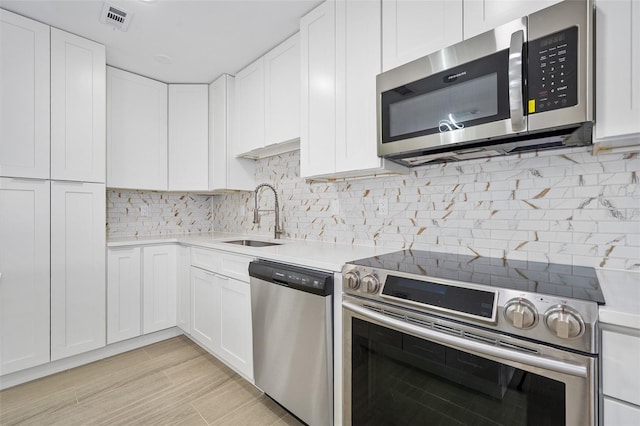 3 Fenwood Ln, Palm Coast, FL 32137 - kitchen with stainless steel appliances, light countertops, white cabinetry, and backsplash