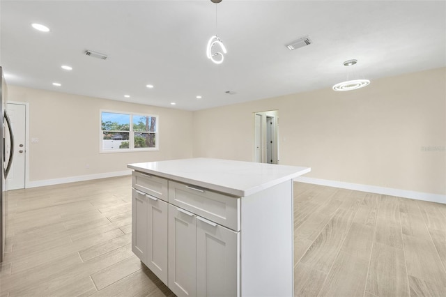 3 Fenwood Ln, Palm Coast, FL 32137 - kitchen with light wood-style flooring, a center island, light countertops, open floor plan, and pendant lighting