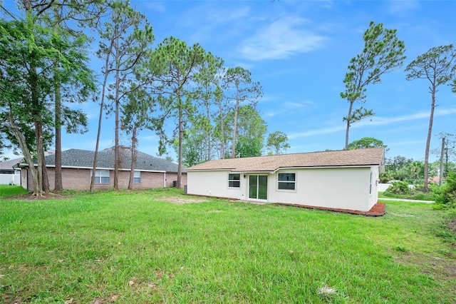 3 Fenwood Ln, Palm Coast, FL 32137 - back of house featuring a yard and stucco siding