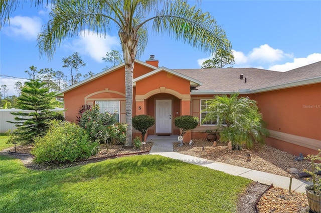 5 Zorlou Ct, Palm Coast, FL 32164 - view of front of home with a front yard, stucco siding, a chimney, and a shingled roof