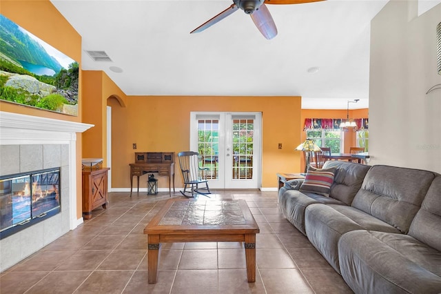 5 Zorlou Ct, Palm Coast, FL 32164 - living room featuring a ceiling fan, tile patterned flooring, a tiled fireplace, and french doors