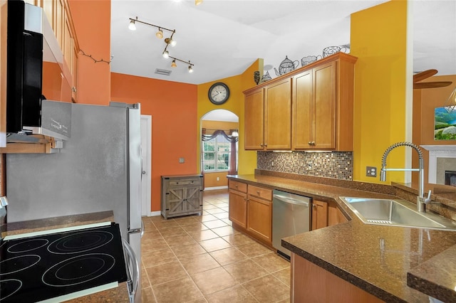 5 Zorlou Ct, Palm Coast, FL 32164 - kitchen with lofted ceiling, stainless steel appliances, light tile patterned floors, decorative backsplash, and track lighting