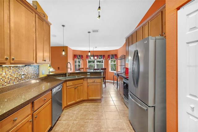 5 Zorlou Ct, Palm Coast, FL 32164 - kitchen with stainless steel appliances, decorative backsplash, brown cabinetry, a peninsula, and decorative light fixtures