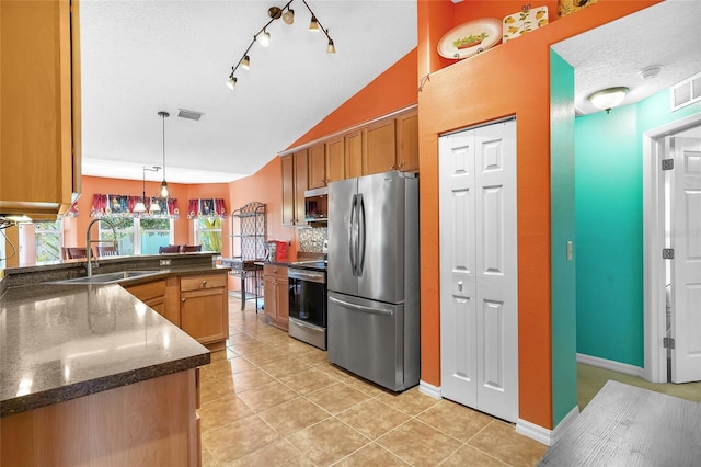 5 Zorlou Ct, Palm Coast, FL 32164 - kitchen featuring appliances with stainless steel finishes, lofted ceiling, brown cabinets, light tile patterned floors, and pendant lighting