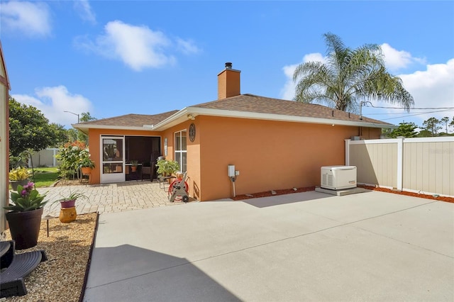 5 Zorlou Ct, Palm Coast, FL 32164 - rear view of property featuring stucco siding, a patio area, a chimney, a sunroom, and a shingled roof