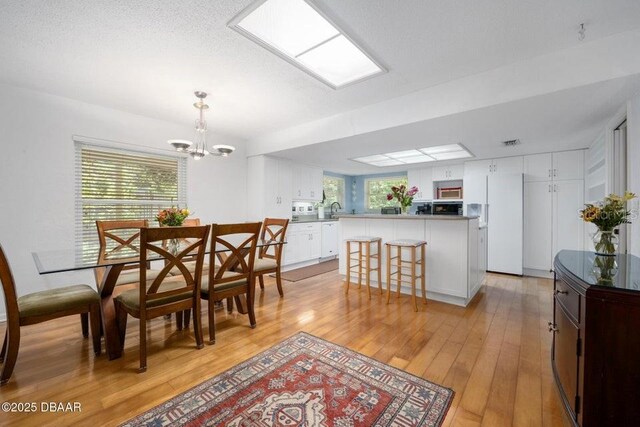 1108 Northside Dr, Ormond Beach, FL 32174 - dining room featuring a chandelier and light wood-type flooring