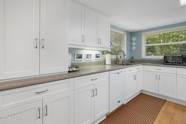 1108 Northside Dr, Ormond Beach, FL 32174 - kitchen featuring white dishwasher, white cabinets, light wood-style flooring, and a textured ceiling