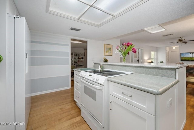 1108 Northside Dr, Ormond Beach, FL 32174 - kitchen featuring white appliances, light wood-style flooring, white cabinetry, open floor plan, and light countertops