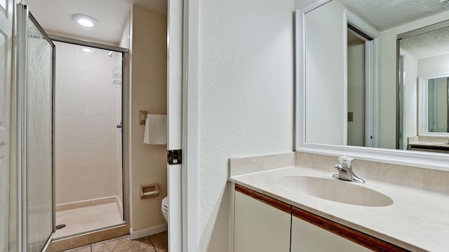 4655 46th Street Ct W Unit 101, Bradenton, FL 34210 - full bathroom featuring a stall shower, a textured ceiling, vanity, and tile patterned flooring