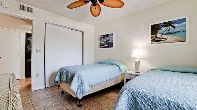 4655 46th Street Ct W Unit 101, Bradenton, FL 34210 - bedroom with tile patterned floors, a closet, a ceiling fan, and a textured ceiling