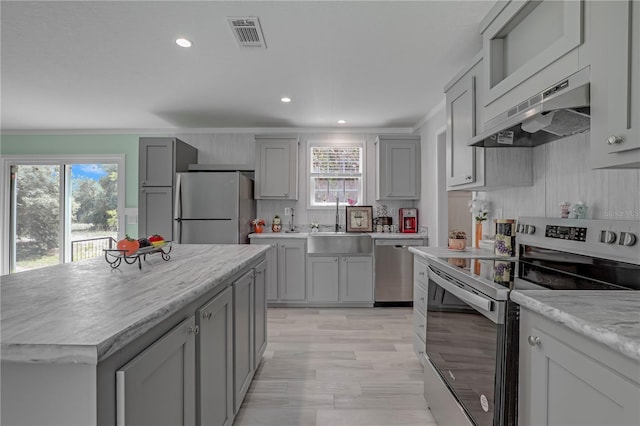 606 Ofarrell Ave, Interlachen, FL 32148 - kitchen featuring appliances with stainless steel finishes, under cabinet range hood, gray cabinetry, plenty of natural light, and recessed lighting