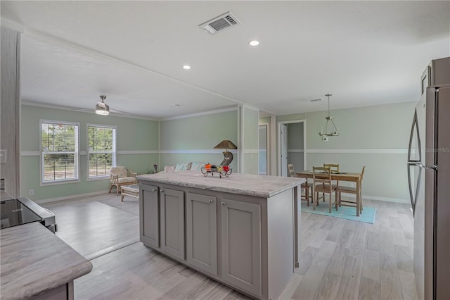 606 Ofarrell Ave, Interlachen, FL 32148 - kitchen with freestanding refrigerator, gray cabinets, light wood-style flooring, a ceiling fan, and hanging light fixtures