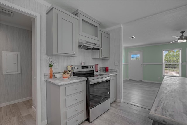 606 Ofarrell Ave, Interlachen, FL 32148 - kitchen with stainless steel electric stove, under cabinet range hood, light wood finished floors, light countertops, and gray cabinetry