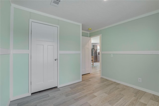 606 Ofarrell Ave, Interlachen, FL 32148 - unfurnished bedroom featuring wood finished floors, freestanding refrigerator, and ornamental molding