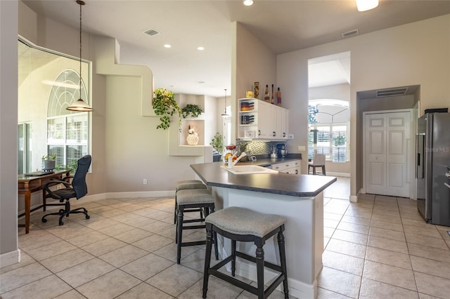 7 Lewis Shire Way, Palm Coast, FL 32137 - kitchen featuring stainless steel fridge, dark countertops, light tile patterned floors, a desk, and recessed lighting