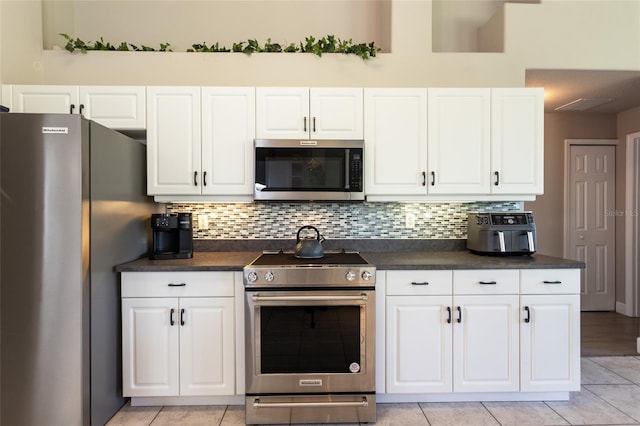 7 Lewis Shire Way, Palm Coast, FL 32137 - kitchen with stainless steel appliances, dark countertops, white cabinetry, and tasteful backsplash