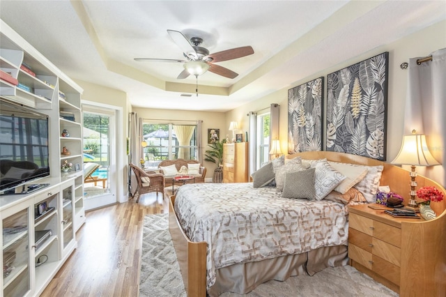 20 Long Pl, Palm Coast, FL 32137 - bedroom with access to outside, a tray ceiling, light wood finished floors, and ceiling fan