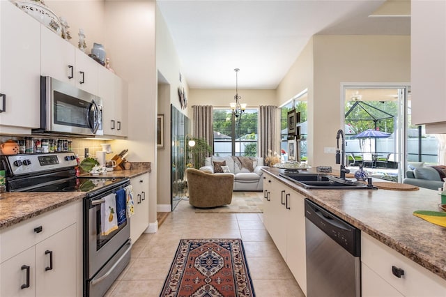 20 Long Pl, Palm Coast, FL 32137 - kitchen with stainless steel appliances, open floor plan, white cabinets, and a chandelier