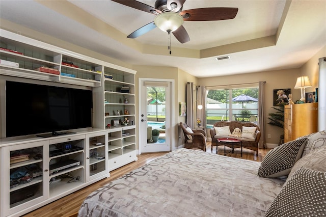 20 Long Pl, Palm Coast, FL 32137 - bedroom with access to outside, a tray ceiling, wood finished floors, and a ceiling fan
