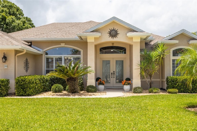 20 Long Pl, Palm Coast, FL 32137 - view of exterior entry featuring french doors, stucco siding, roof with shingles, and a lawn
