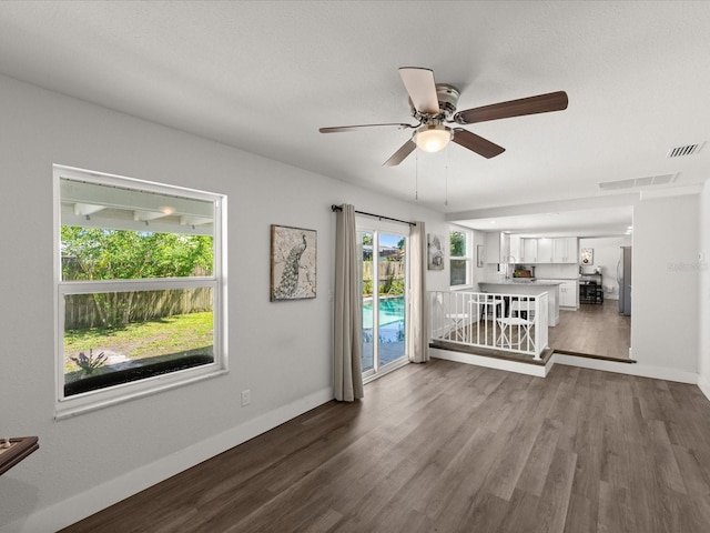 506 Dorset Cir S, Daytona, FL 32119 - unfurnished living room featuring ceiling fan and dark wood-style floors