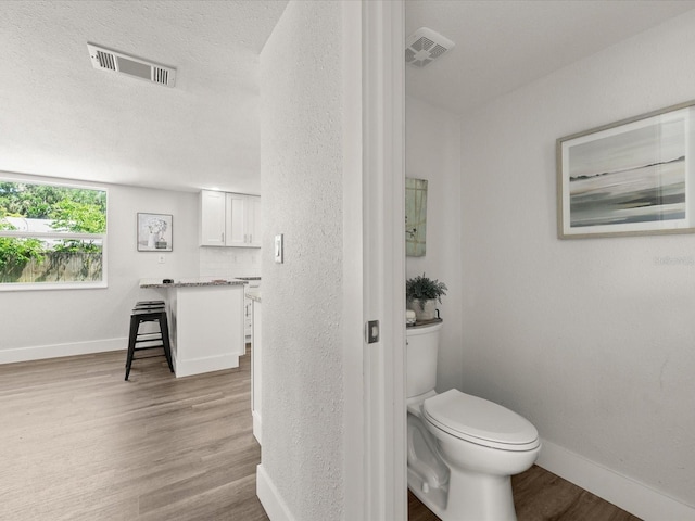 506 Dorset Cir S, Daytona, FL 32119 - bathroom featuring wood finished floors, a textured wall, vanity, and a textured ceiling