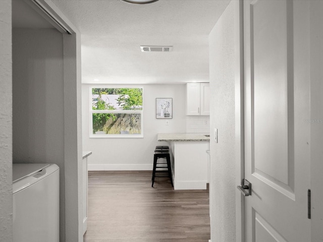506 Dorset Cir S, Daytona, FL 32119 - washroom featuring wood finished floors, washer / dryer, and a textured ceiling