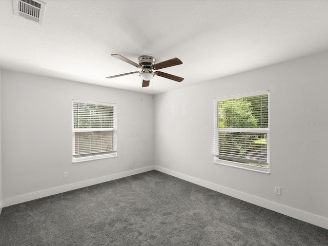 506 Dorset Cir S, Daytona, FL 32119 - spare room with plenty of natural light, ceiling fan, and dark colored carpet
