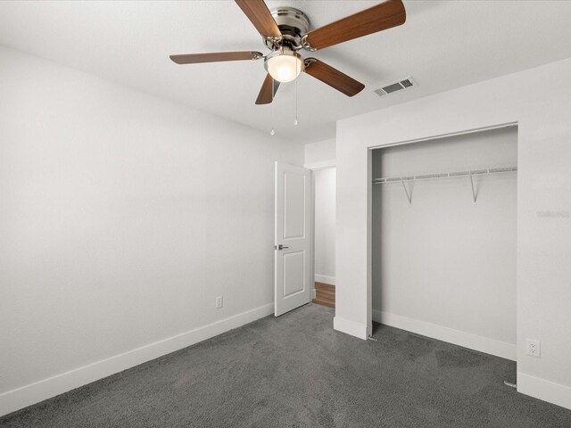506 Dorset Cir S, Daytona, FL 32119 - unfurnished bedroom featuring dark carpet, a closet, and a ceiling fan