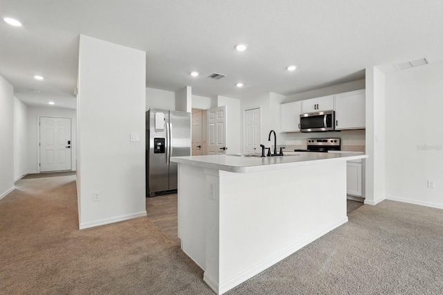 17 Roxbury Ln, Palm Coast, FL 32164 - kitchen with appliances with stainless steel finishes, light carpet, light countertops, recessed lighting, and an island with sink
