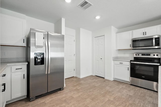 17 Roxbury Ln, Palm Coast, FL 32164 - kitchen with appliances with stainless steel finishes, light countertops, white cabinets, recessed lighting, and light wood finished floors