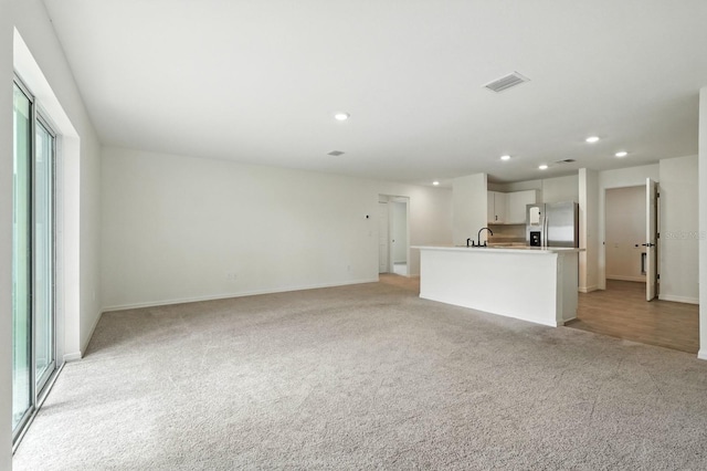 17 Roxbury Ln, Palm Coast, FL 32164 - unfurnished living room featuring light carpet and recessed lighting