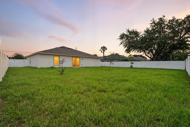 17 Roxbury Ln, Palm Coast, FL 32164 - back of house at dusk featuring a fenced backyard and stucco siding