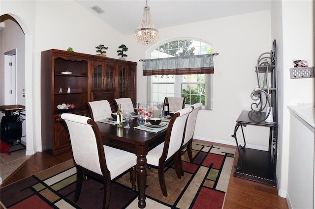 43 White Dove Ln, Palm Coast, FL 32164 - dining room featuring lofted ceiling, wood finished floors, arched walkways, and a chandelier