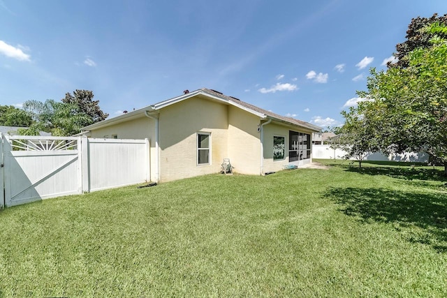 43 White Dove Ln, Palm Coast, FL 32164 - back of house featuring stucco siding and a gate