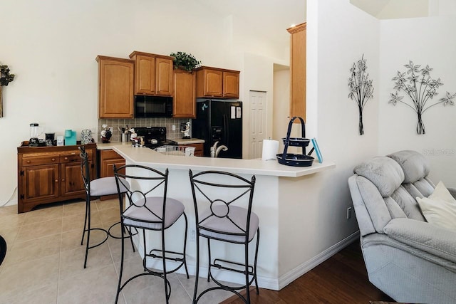 43 White Dove Ln, Palm Coast, FL 32164 - kitchen featuring black appliances, a peninsula, a kitchen bar, open floor plan, and light countertops