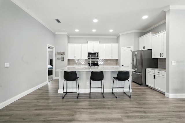47 Lumberjack Trl, Palm Coast, FL 32137 - kitchen featuring stainless steel appliances, recessed lighting, a center island with sink, white cabinetry, and crown molding