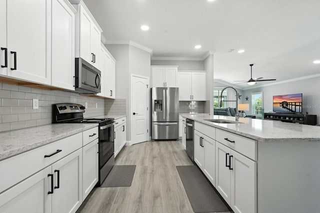 47 Lumberjack Trl, Palm Coast, FL 32137 - kitchen featuring stainless steel appliances, ornamental molding, a ceiling fan, white cabinetry, and a kitchen island with sink