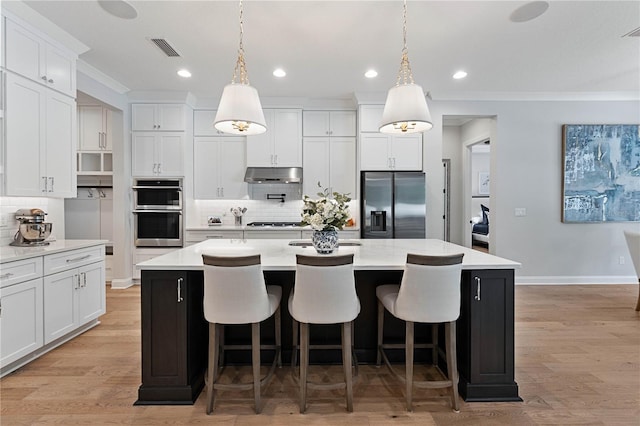 233 Yorkshire Dr, Saint Augustine, FL 32092 - kitchen featuring appliances with stainless steel finishes, under cabinet range hood, decorative backsplash, light countertops, and ornamental molding