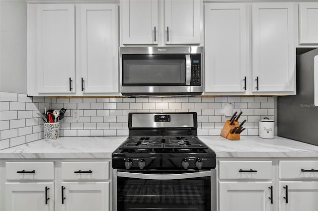 7 Grand Par Ct, Bunnell, FL 32110 - kitchen featuring appliances with stainless steel finishes, white cabinets, tasteful backsplash, and light stone countertops